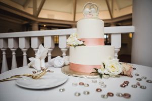 A detailed wedding cake sits on top of a table.