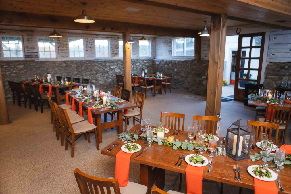A detailed wedding setup with tables and chairs in a room.