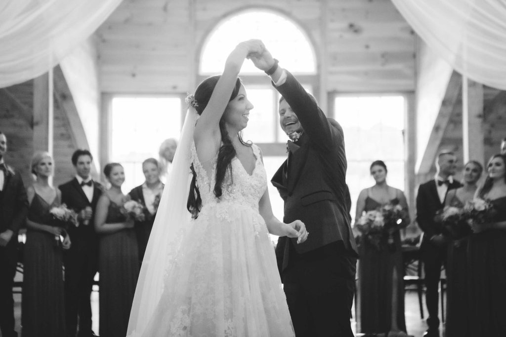 Black and white photo of bride and groom sharing their first dance at their wedding reception.