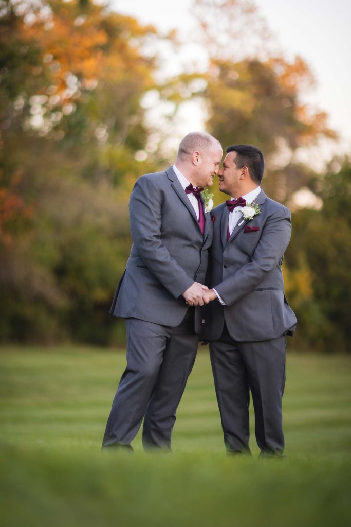 Portrait of two grooms in suits at their wedding.