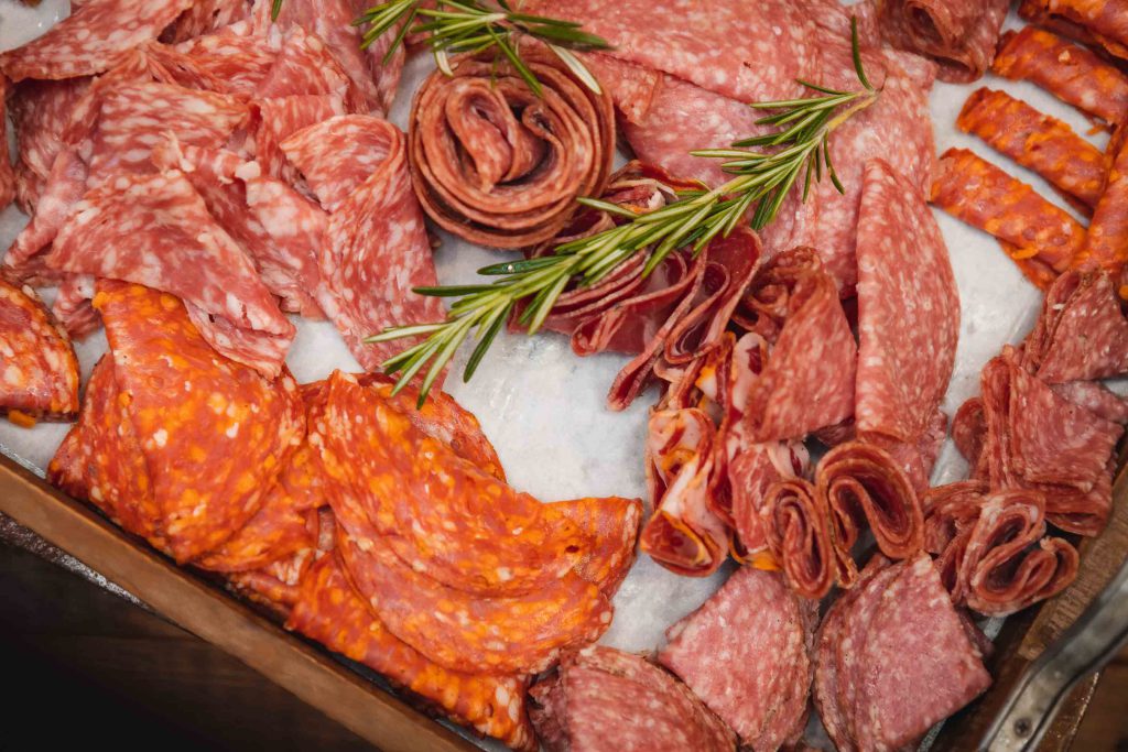 A tray full of different kinds of meats for a wedding event.