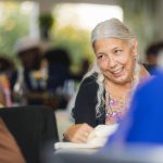 An older woman smiles at a wedding reception.