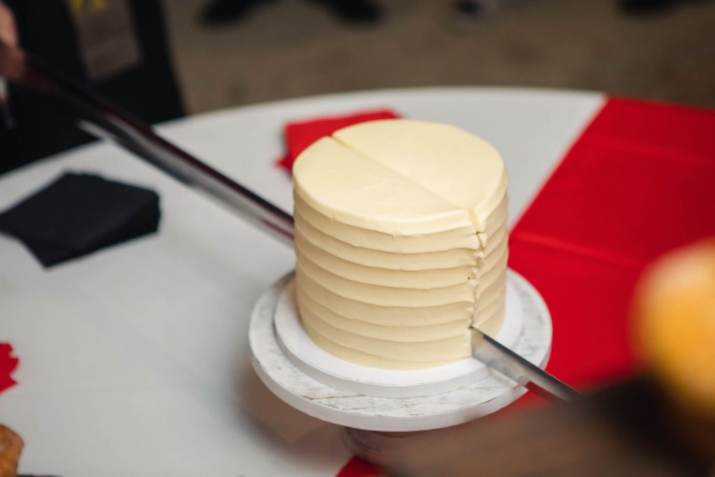 A person cutting a cake with a knife at a wedding reception.