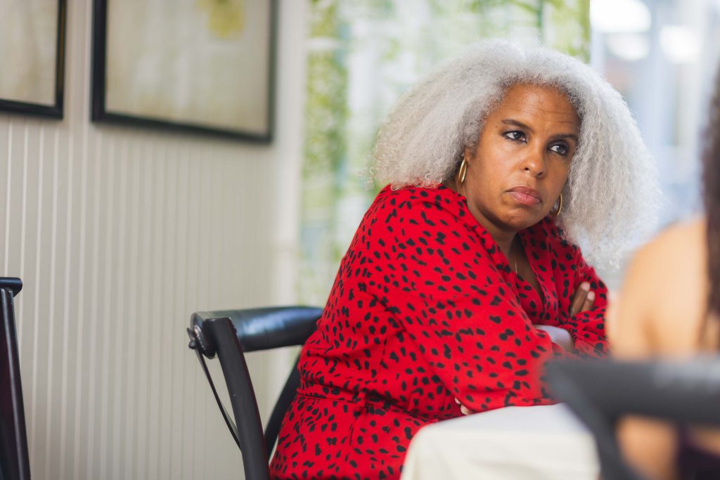 A woman with gray hair sitting at a wedding reception table.