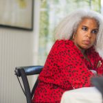 A woman with gray hair sitting at a wedding reception table.