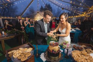 A couple celebrating their wedding by cutting their cake at the reception.