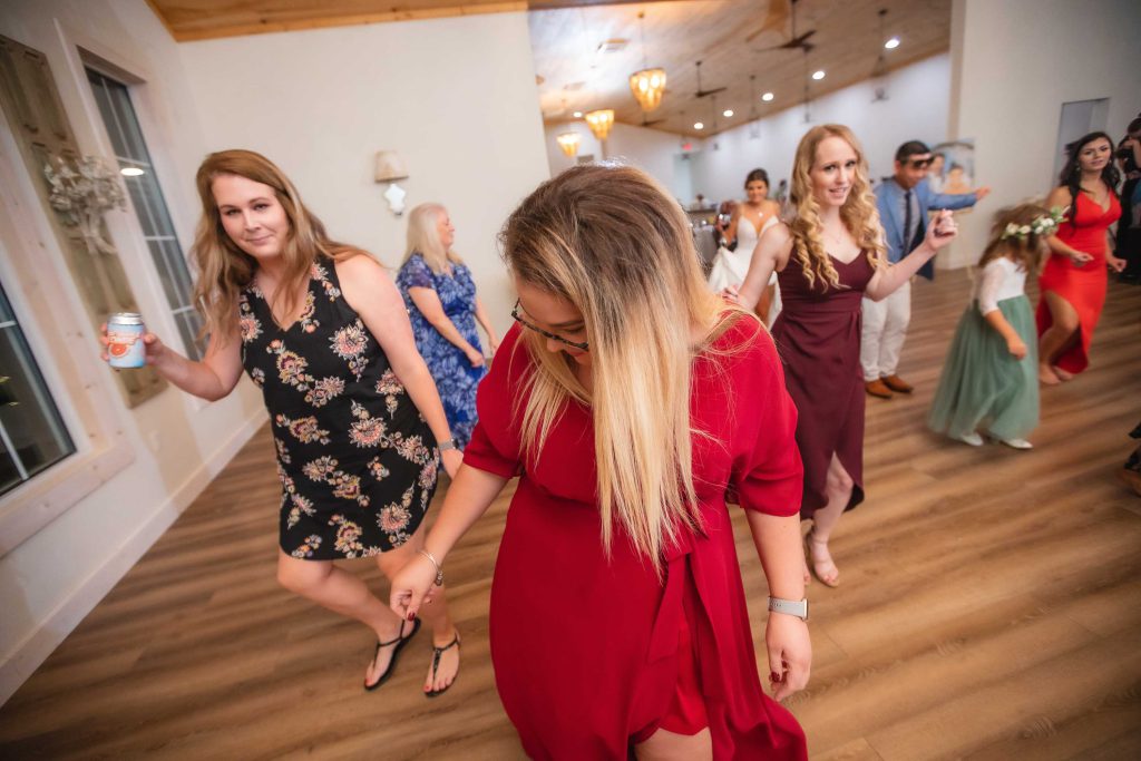 A group of bridesmaids dancing at a wedding reception.