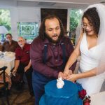 A couple cutting their wedding cake at their reception.