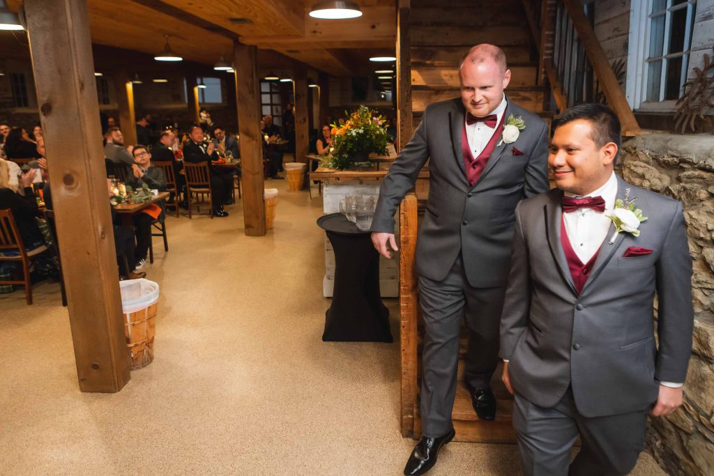 Two groomsmen descending stairs at a wedding reception.