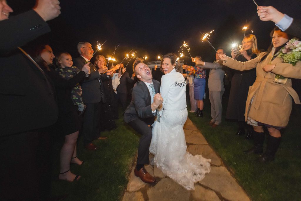 A bride and groom kissing with sparklers at their wedding reception.