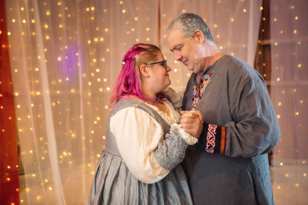 A couple dancing in medieval costumes at their wedding reception.