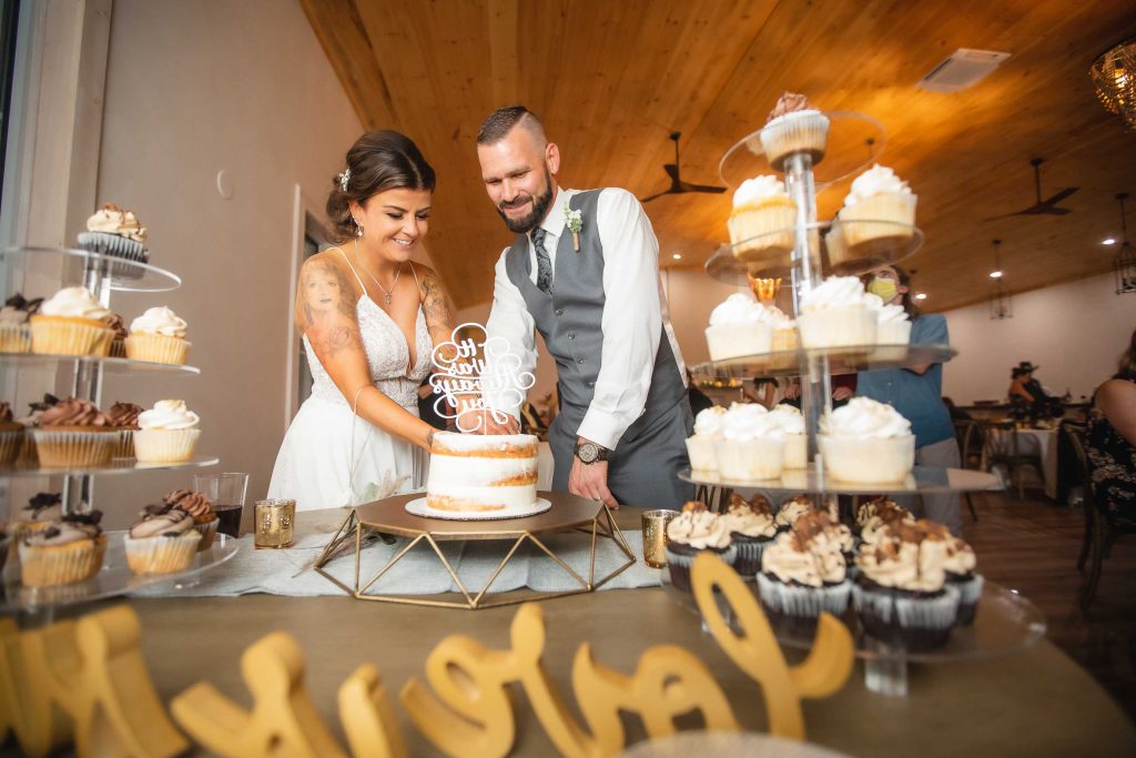 A bride and groom cutting their wedding cake during the reception.