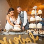 A bride and groom cutting their wedding cake during the reception.
