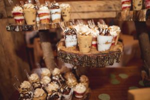 A wedding dessert table displaying cupcakes on a wooden stand.