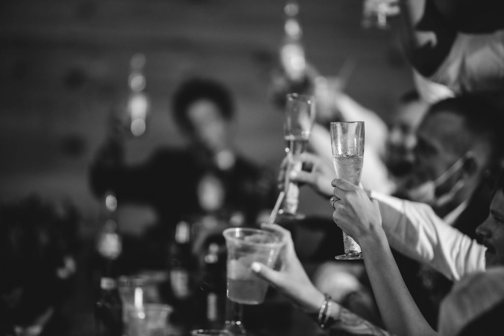 A black and white photo of people toasting at a wedding reception.