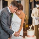 A wedding reception moment: Bride and groom cutting their wedding cake.