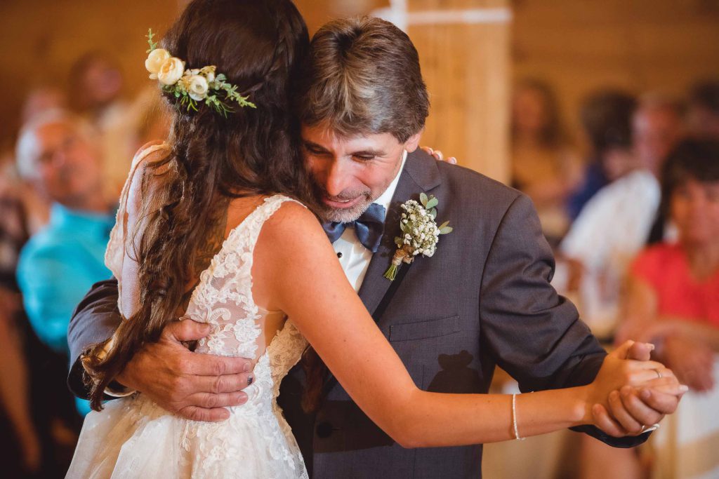 A bride and groom hugging during their wedding reception.