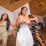 A bride and her bridesmaids dancing at a wedding reception.