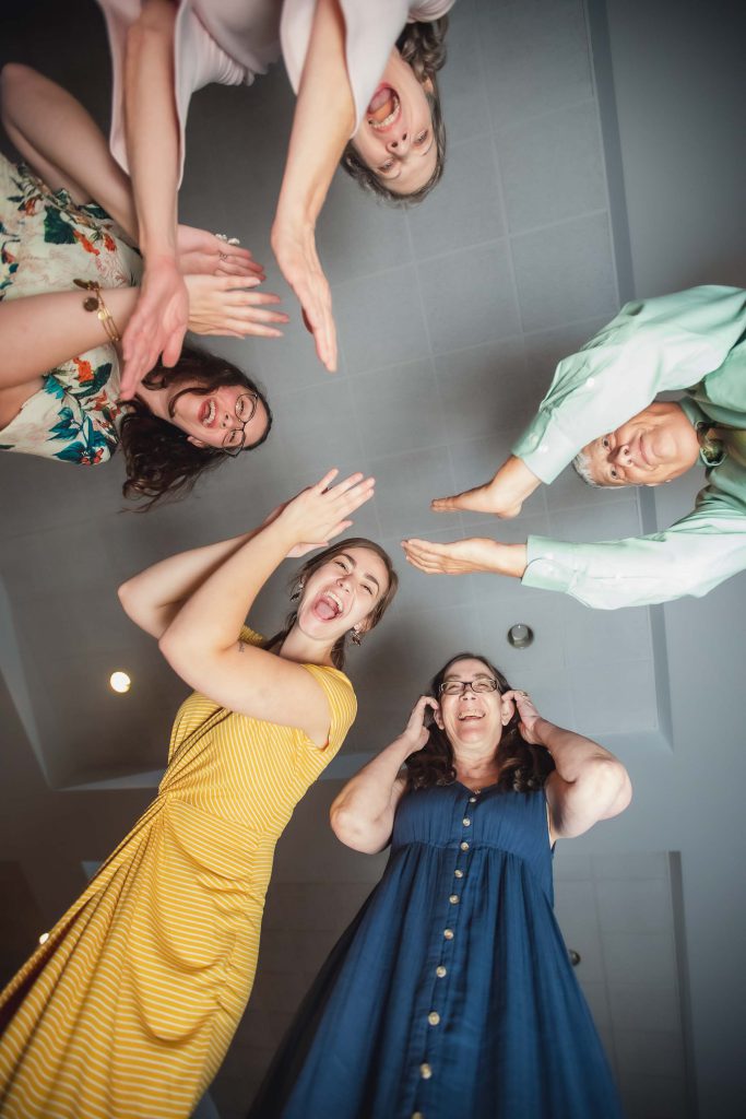 A group of women raising their hands in celebration at a wedding reception.