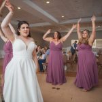A group of bridesmaids dancing at a wedding reception.