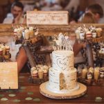 A detailed wedding cake is sitting on a wooden table.