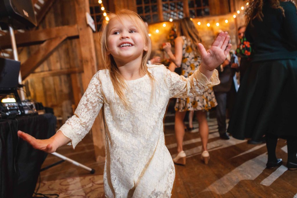 Little girl dancing on the dance floor at a wedding reception.