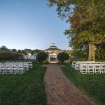 A wedding ceremony set up at night with intricate details and a gazebo.