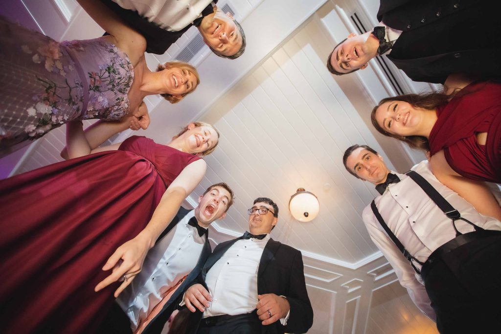 A group of people in tuxedos posing for a photo during a wedding.