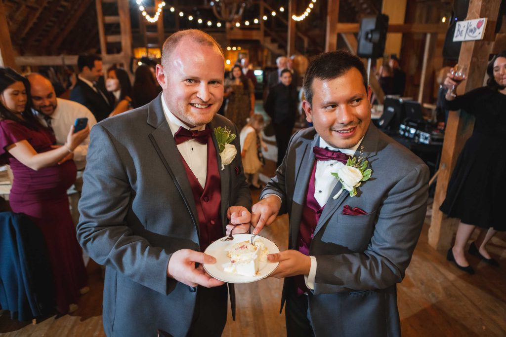 Two grooms celebrating their wedding with a cake at the reception.