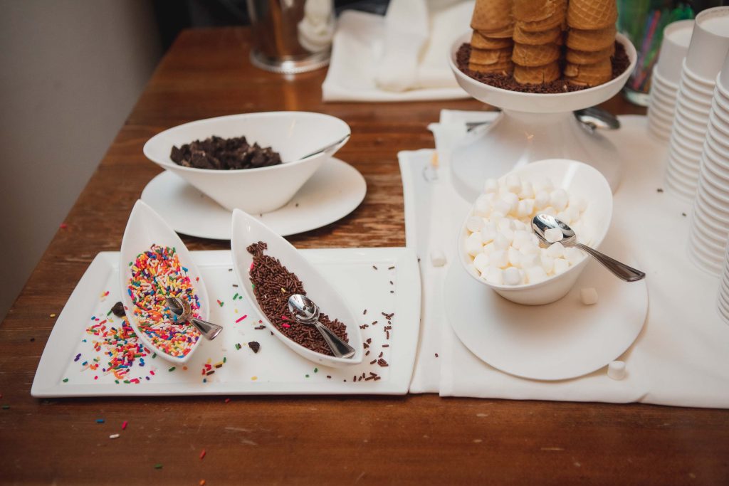 Wedding details: Ice cream cones and sprinkles on a table.