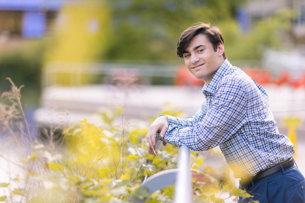 A young man posing for a graduation portrait.