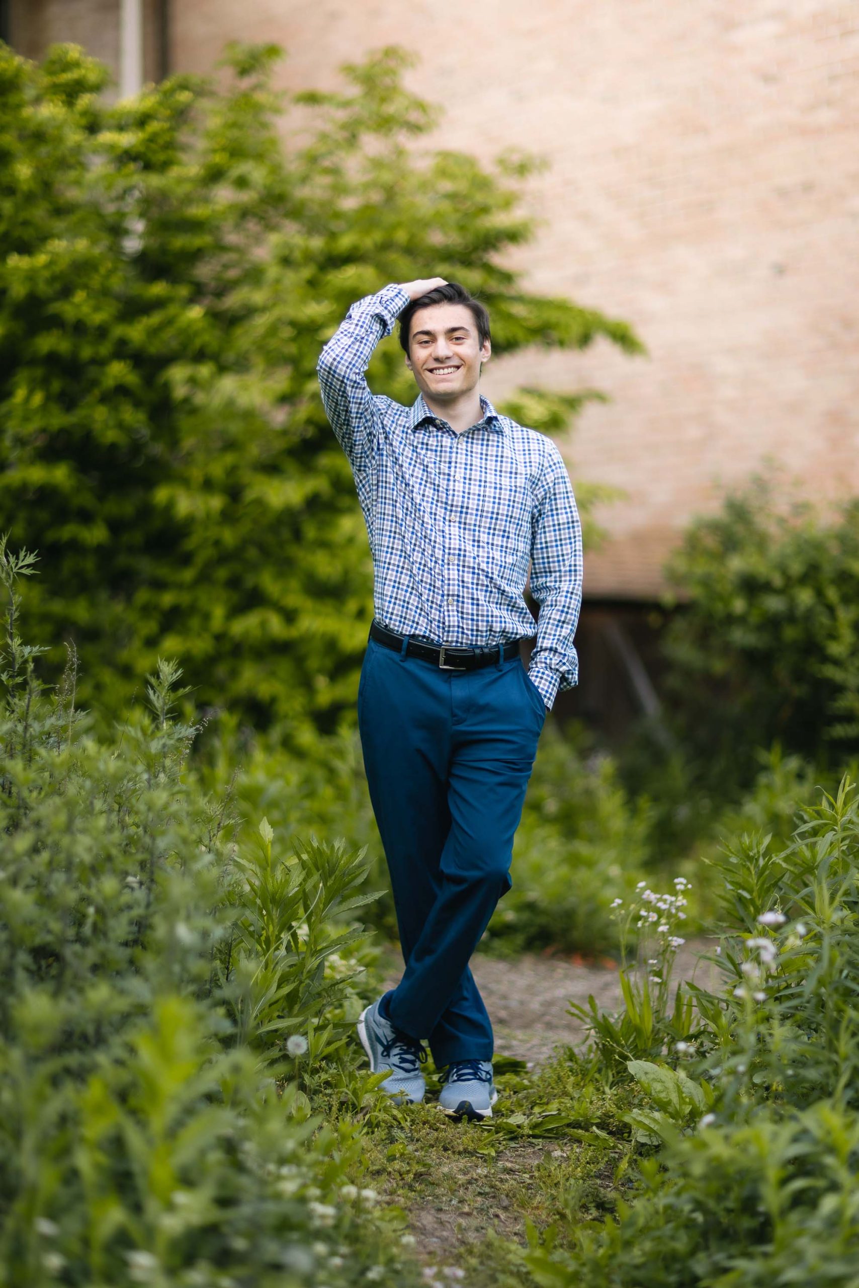 A senior man standing in a grassy area.