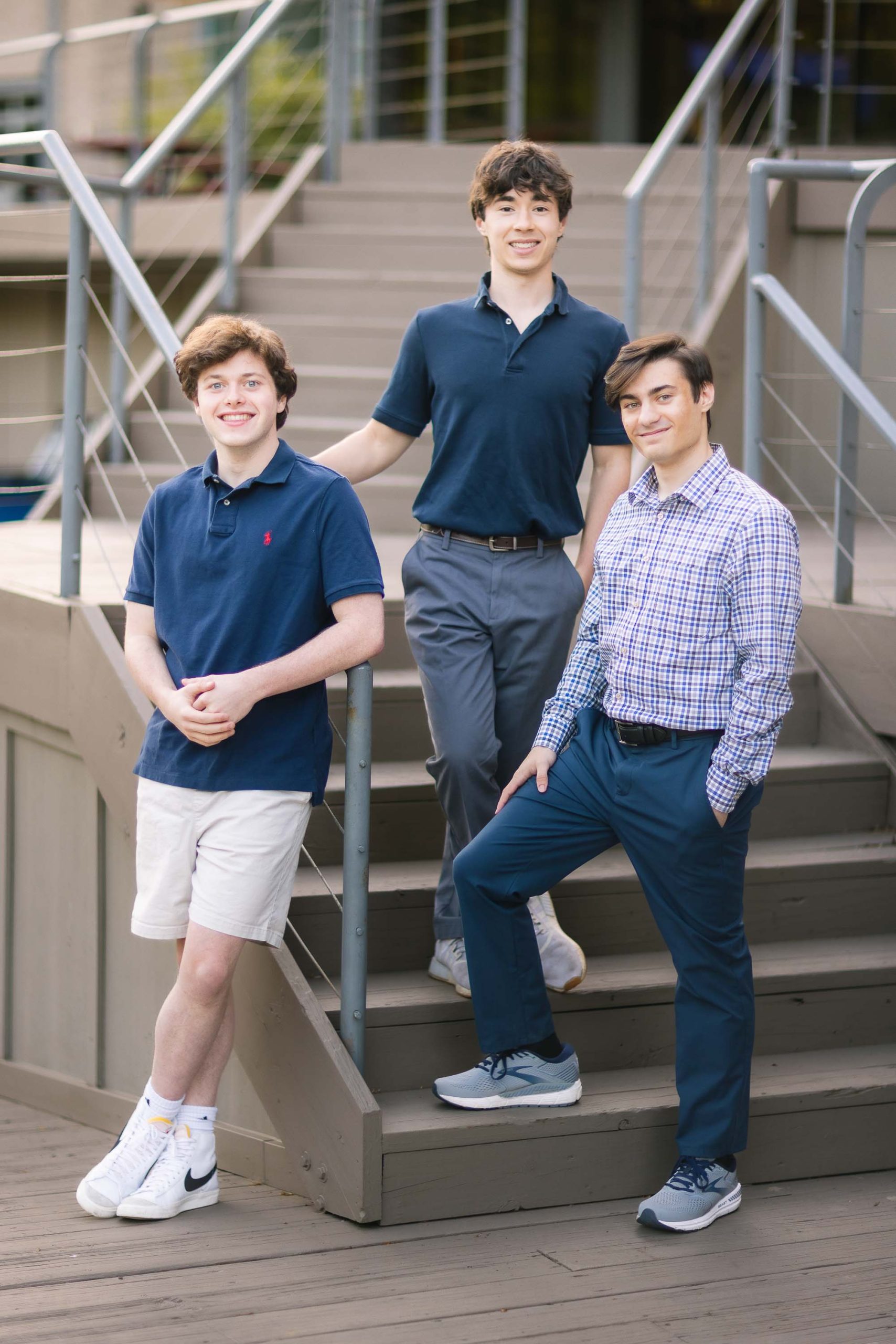 Three high school seniors posing on steps in front of a building.