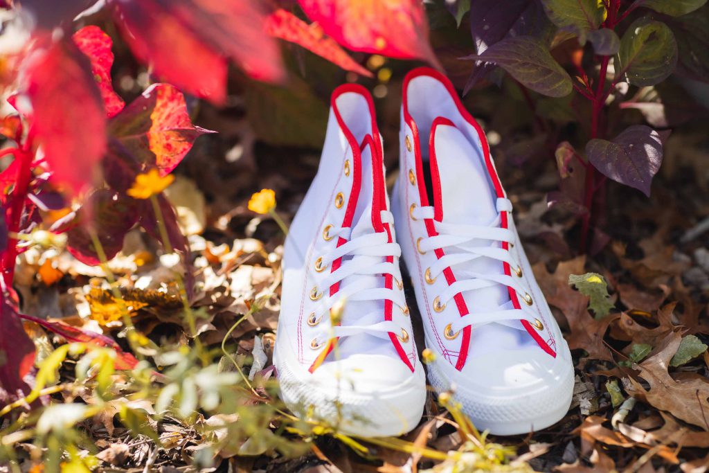 Chuck taylor all star high tops with red and white wedding details.