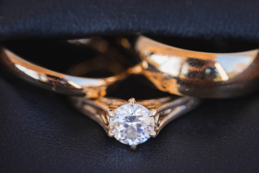 A diamond-studded gold wedding ring with intricate details.