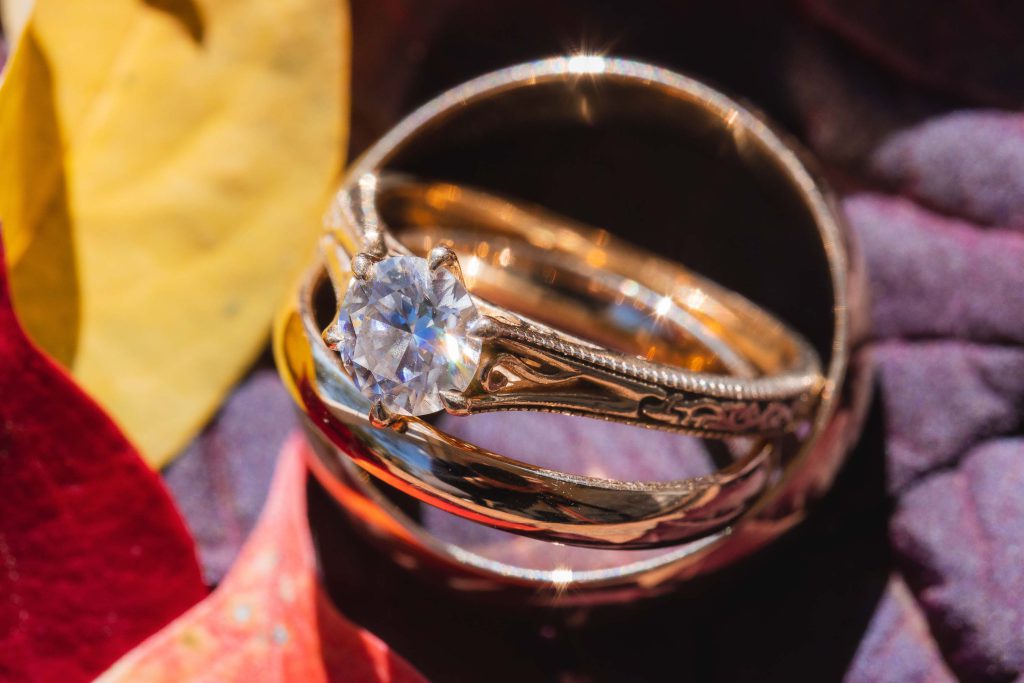 A wedding ring adorned with autumn leaves.