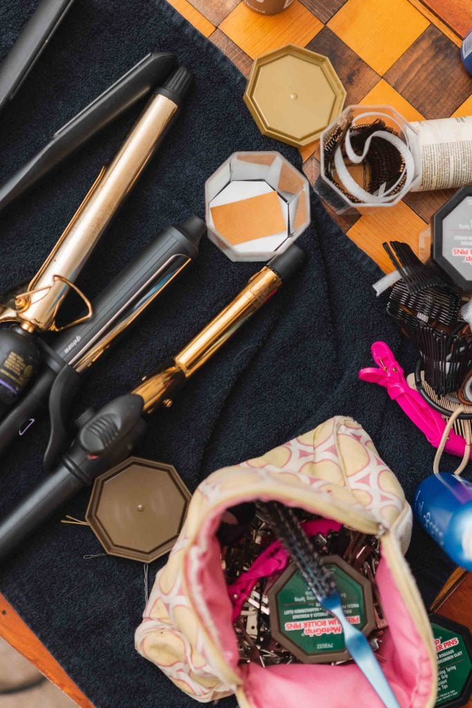 A table showcasing hair styling tools and a bag for wedding details.