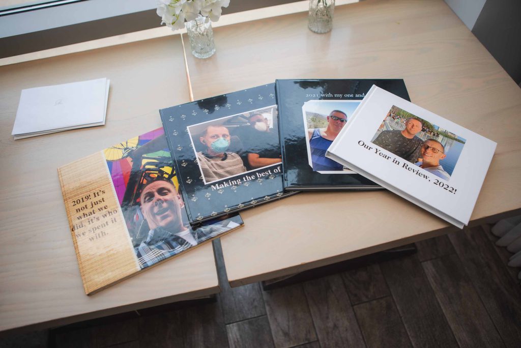 Three birthday party photo books are sitting on a table.