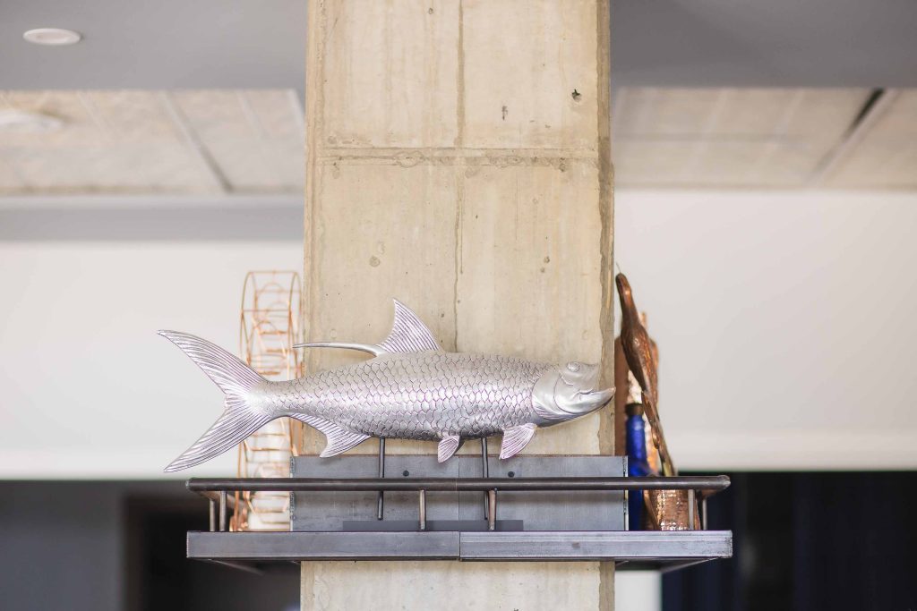 A fish sculpture is displayed on a shelf at a birthday party.