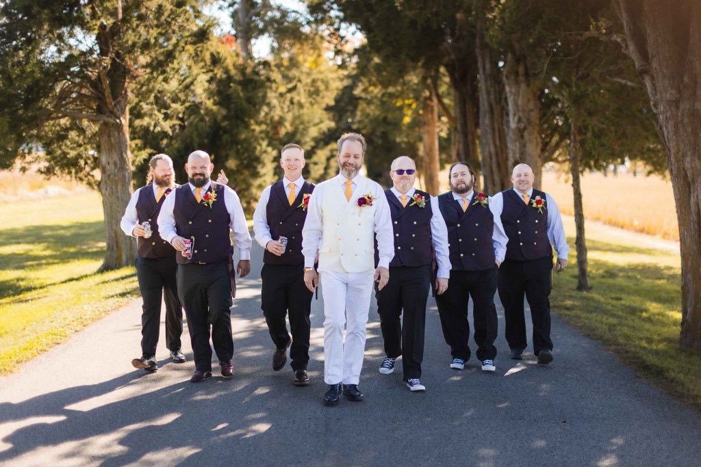 A group of groomsmen posing for a wedding portrait on a path.