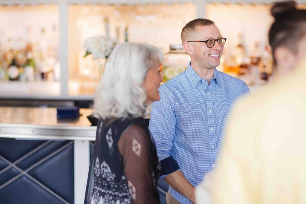 A birthday party group standing at a bar.