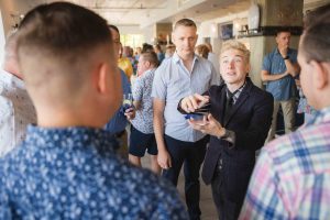 A man in a suit is talking to a group of people at a birthday party.