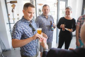 A group of people celebrating a birthday with beer at a bar.