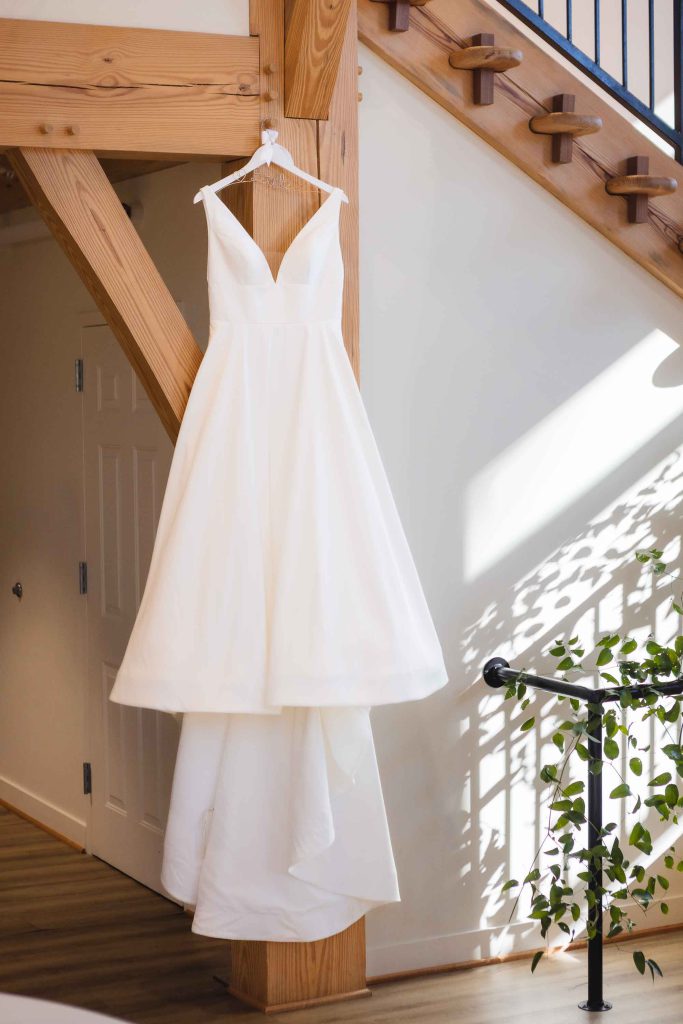 A wedding dress hangs in a room.
