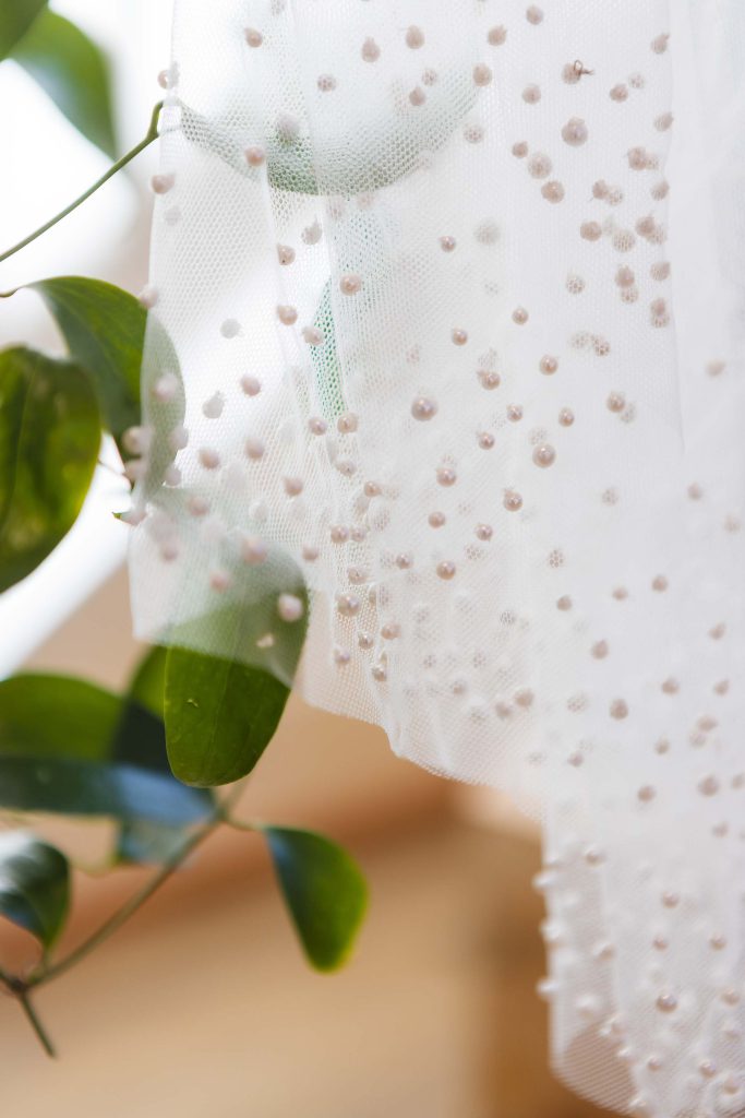 A detailed wedding veil with pearls.