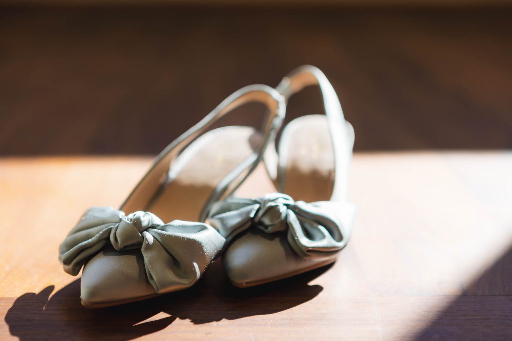 A pair of wedding shoes with a bow on them.