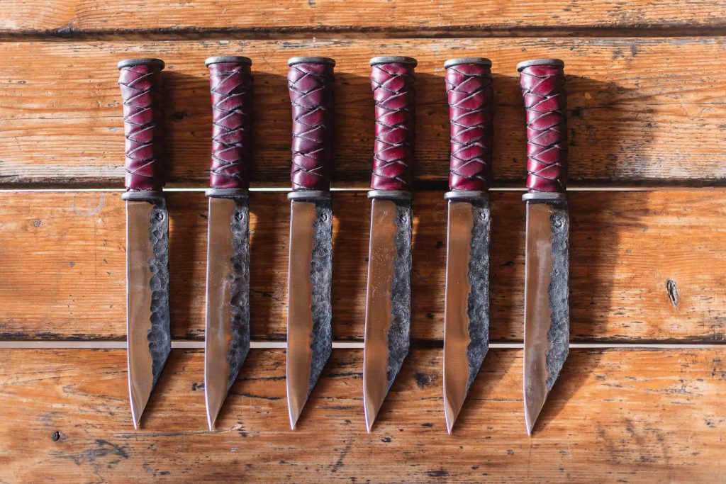 Five knives on a wooden table, wedding details.