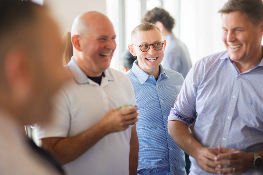 A group of men laughing at a birthday party.