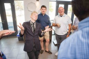 A group of people at a birthday party talking to each other.