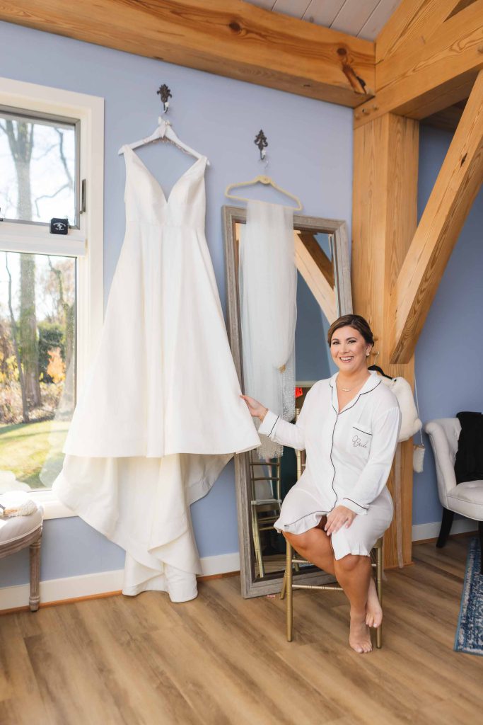 A candid bride preparing for her wedding in front of a mirror.